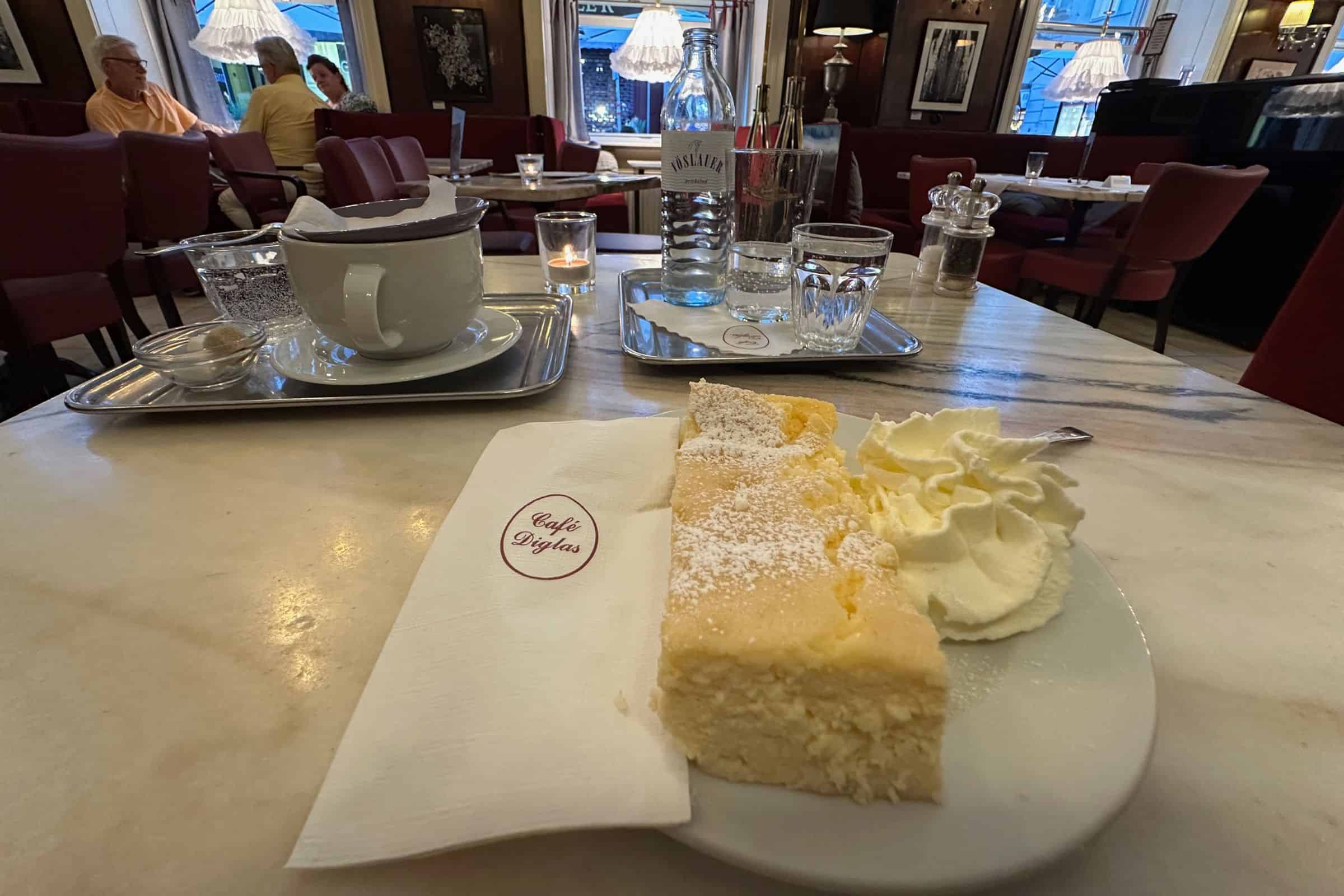 Viennese cheesecake at Café Diglas, Vienna — traditional café dessert with tea service Tea and a torte with fresh whipped cream at the Cafe Diglas in Vienna