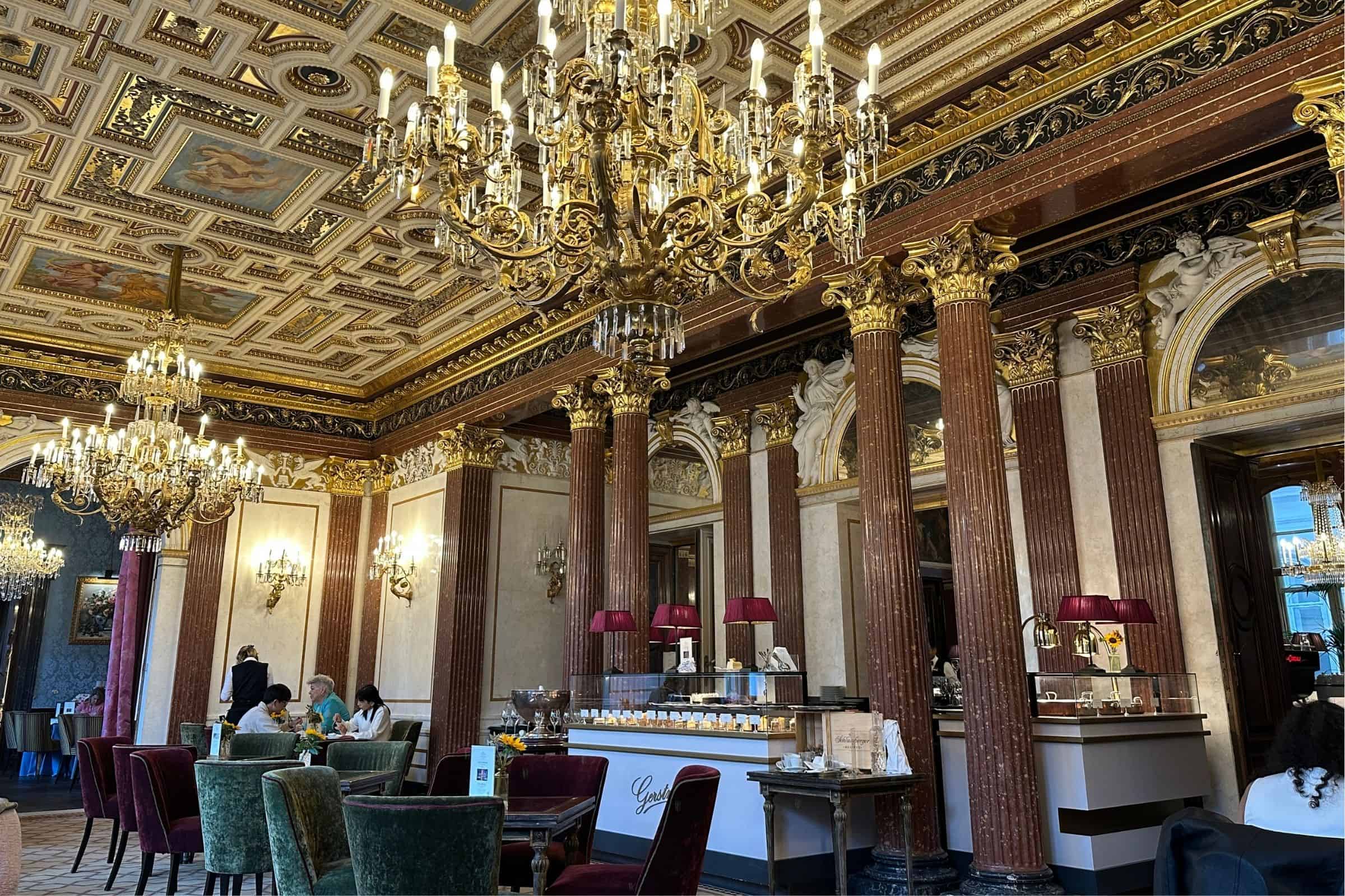 Gerstner Café, Vienna — historic imperial café interior Gerstner Café interior in Vienna with chandeliers, gilded columns, marble details, and upholstered seating