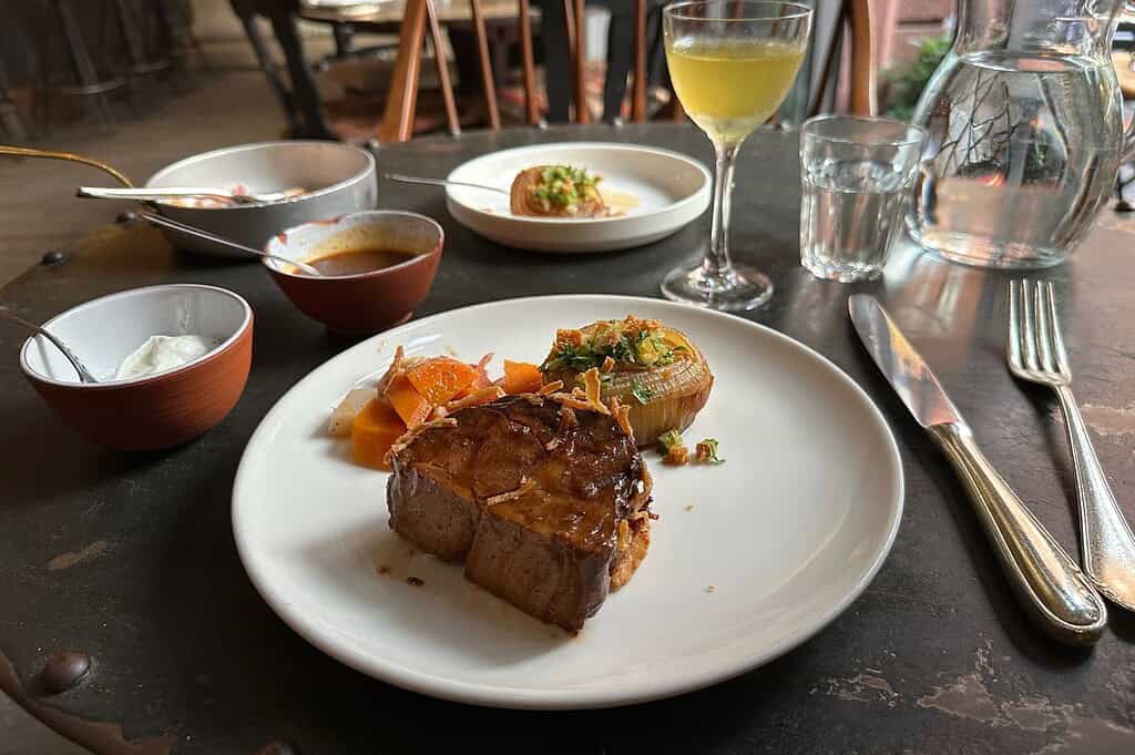 Katz Orange Berlin courtyard dining, followed by a seasonal watermelon and tomato salad and slow-cooked beef brisket served with vegetables and sauces.