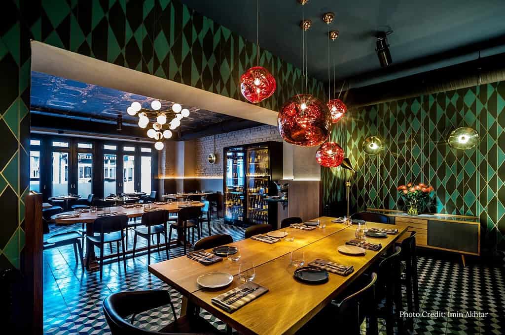 Interior and dining details at Mine Wine Berlin, featuring seasonal cuisine, warm lighting, and modern European design