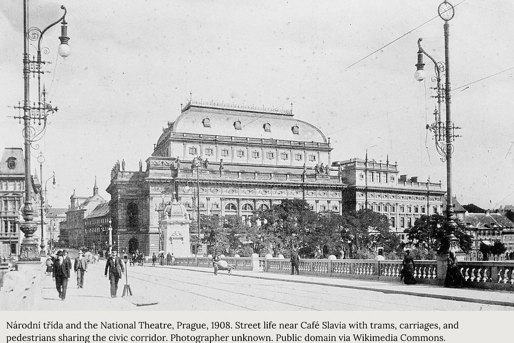 Street life on Národní třída in Prague, c. 1908, with pedestrians, trams, and a horse-drawn carriage near the National Theatre