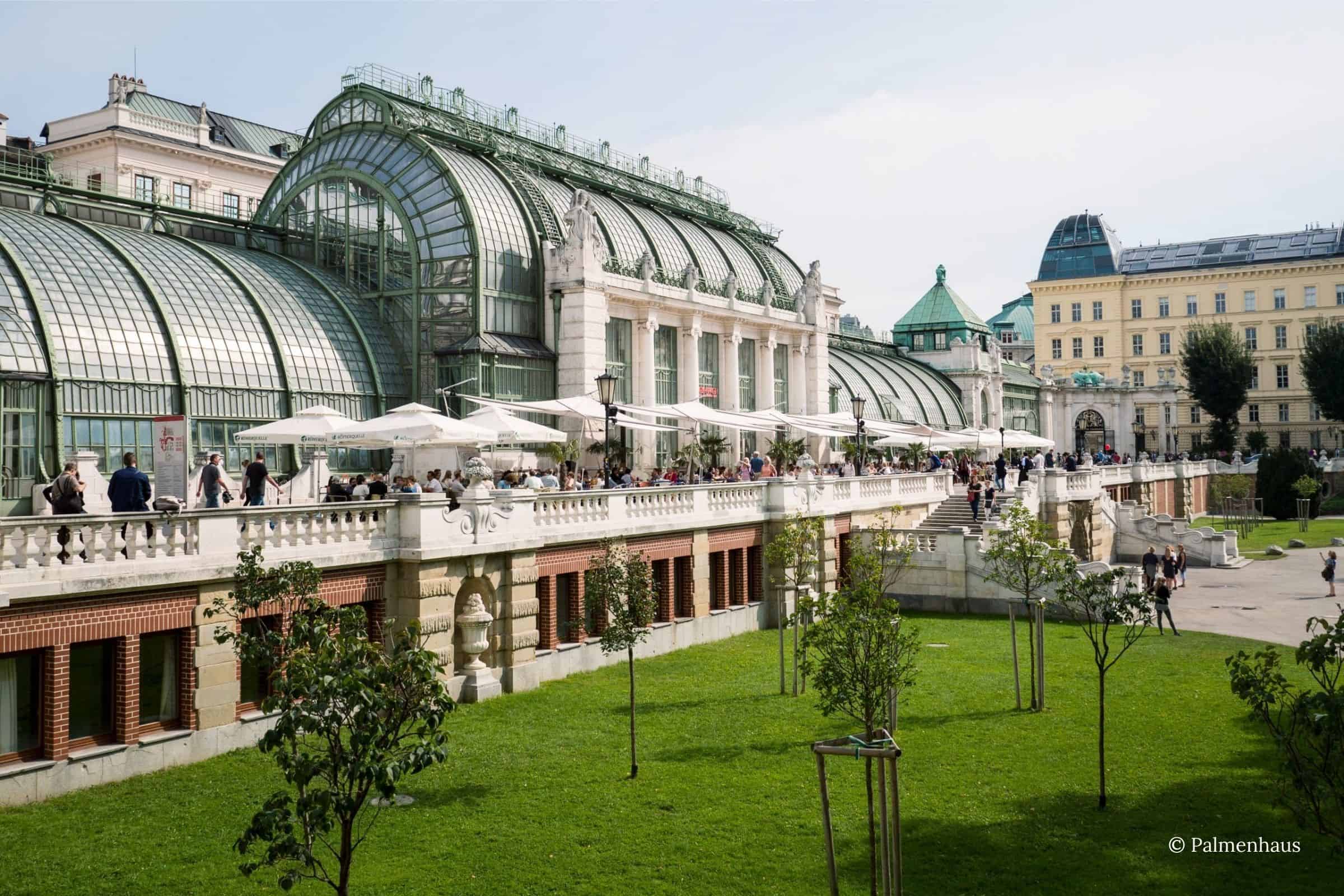 Palmenhaus Vienna terrace overlooking the Burggarten Palmenhaus Vienna exterior with historic glasshouse, outdoor terrace seating, and Burggarten gardens