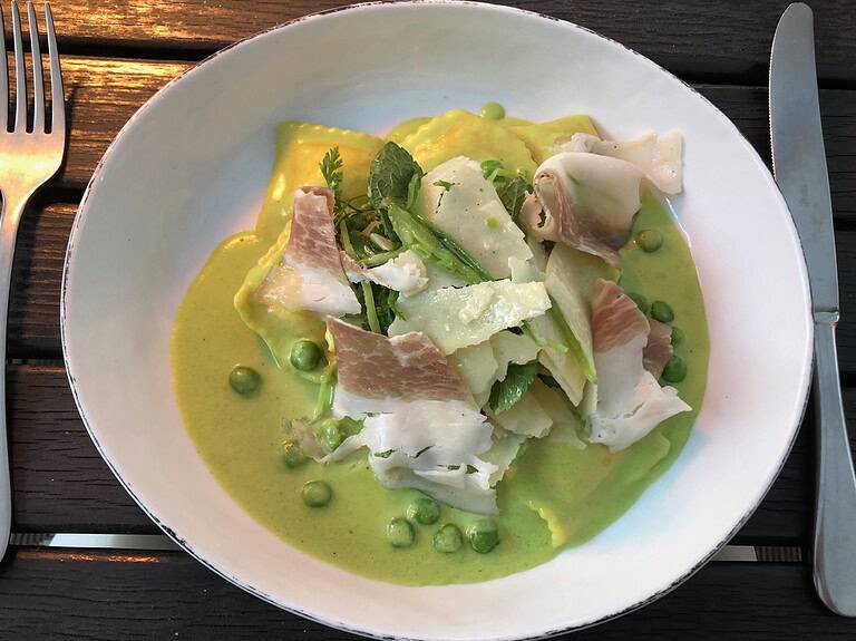 Plated seasonal pasta with green pea sauce and shaved prosciutto at Salonplafond Vienna