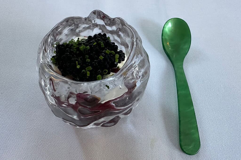 Photo gallery of Tulus Lotrek in Berlin, featuring the garden terrace dining area and plated courses including lobster and caviar, reflecting the restaurant’s refined, seasonal approach to fine dining.