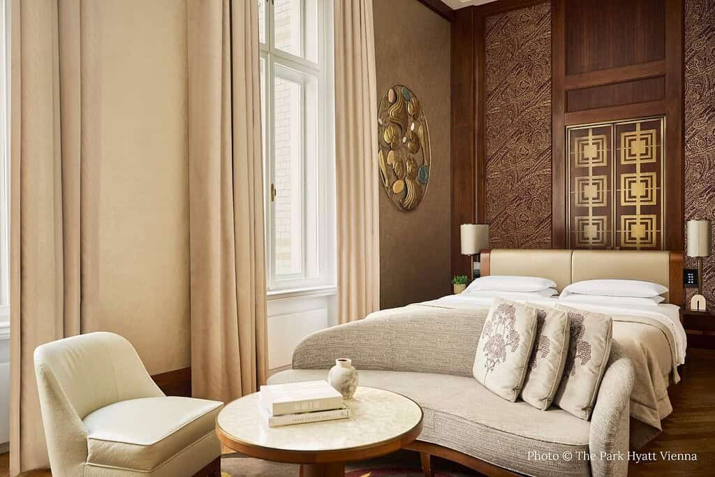 Exterior and interior views of Park Hyatt Vienna on Am Hof, including the former Austro-Hungarian bank façade, a king guest room with wood paneling, and the vaulted indoor pool in the historic treasury