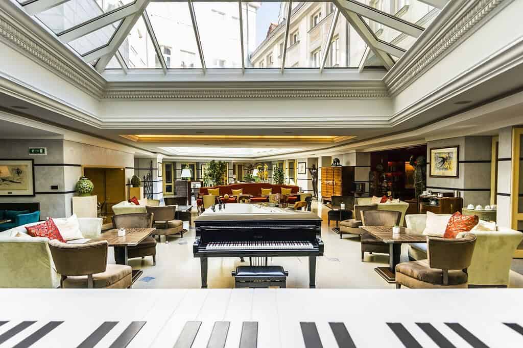 Aria Hotel Prague atrium lounge with grand piano, Mozart suite interior, and view of the Baroque Vrtba Garden in Malá Strana
