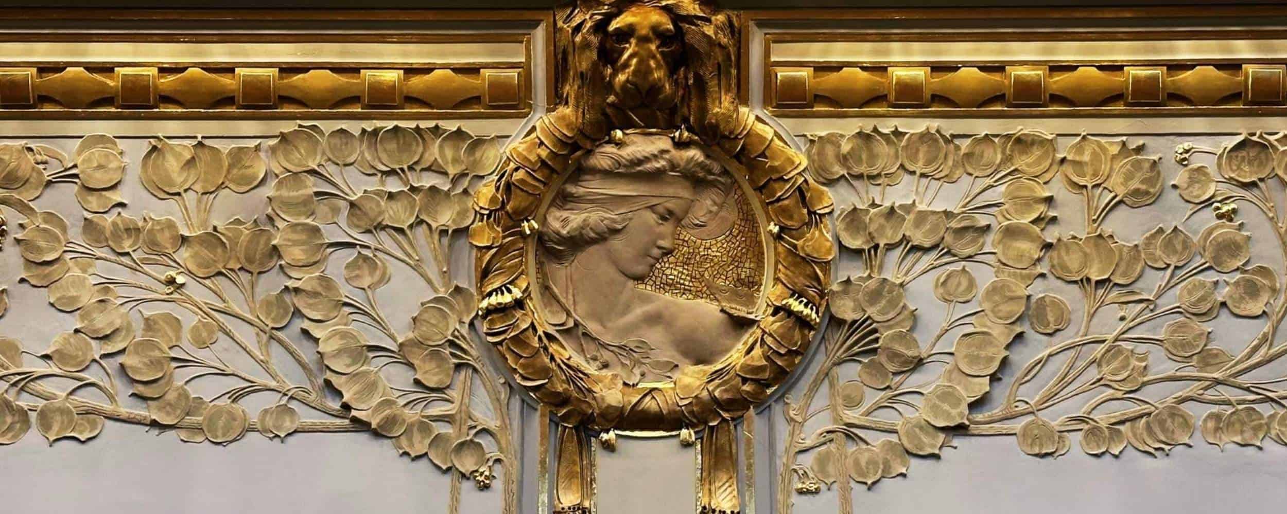 Gilded Art Nouveau relief with a woman’s profile and floral motifs at Prague’s Municipal House
