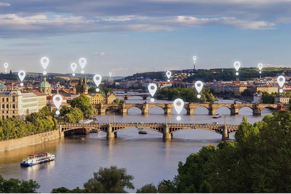 Map pin icons over Prague’s Vltava River and historic bridges