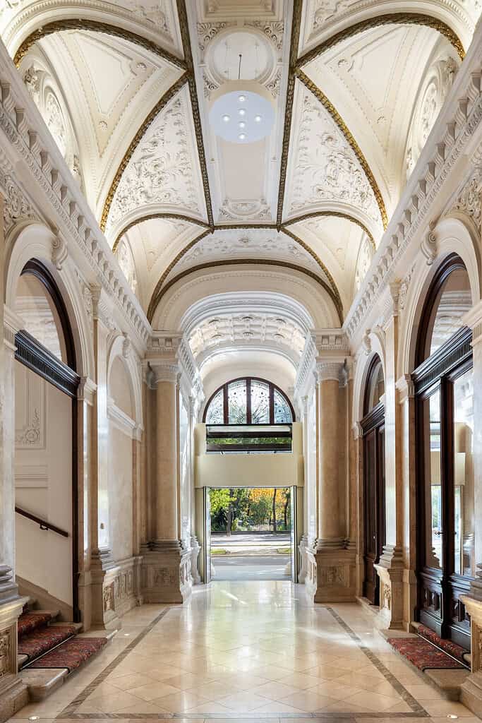 Ornate entry hall of the Almanac Palace hotel in Vienna with exit showing Stadtpark and autumn hued leaves outside