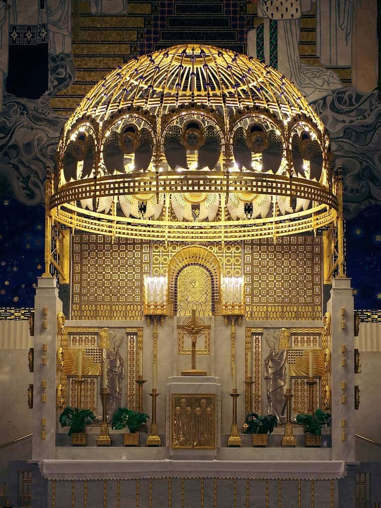Interior of Otto Wagner’s Kirche am Steinhof in Vienna, showing the richly gilded altar, patterned walls, and decorative dome above the sanctuary
