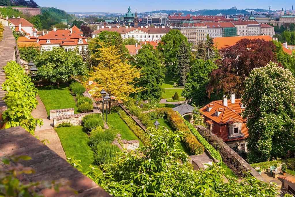 Terraced gardens in Prague with green lawns, terra-cotta rooftops, and city views from the hillside