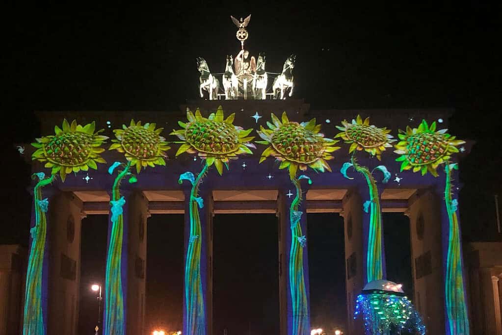 Brandenburg Gate illuminated with colorful sunflower projections during Berlin’s Festival of Lights