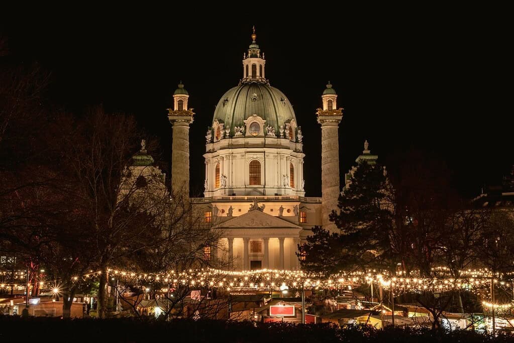 Karlskirche Christmas Market in Vienna, Austria decorated with white lights