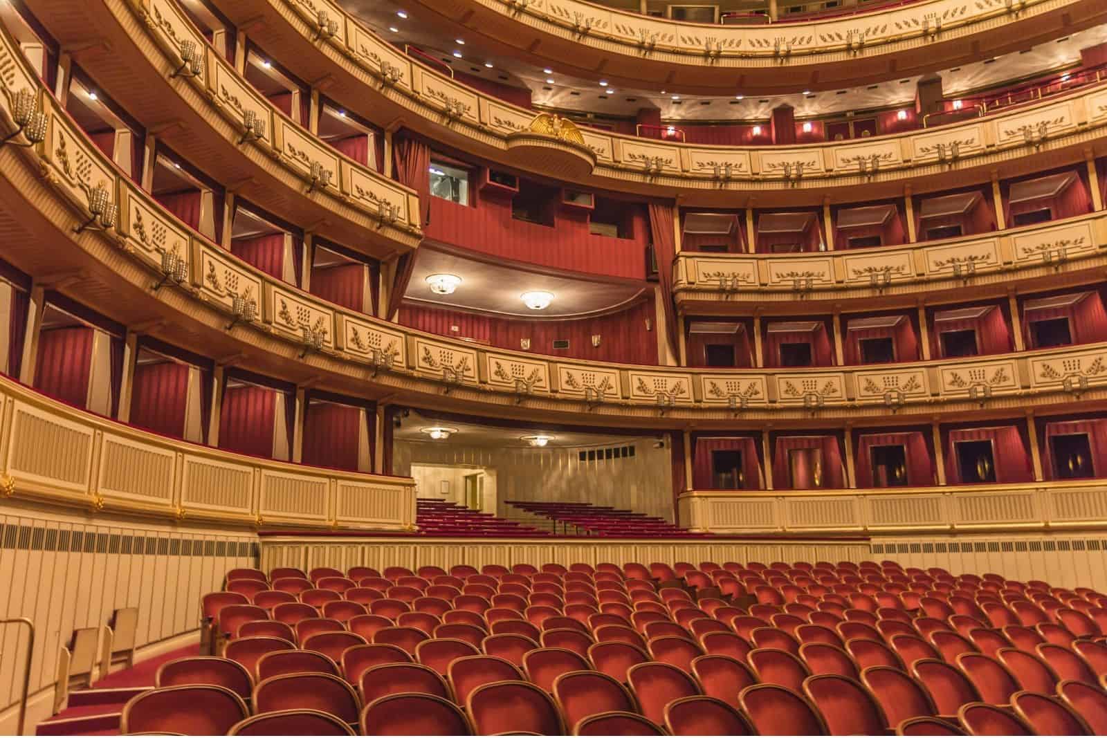 Interior of the Vienna State Opera with red velvet seating, ornate balconies, and gilded details